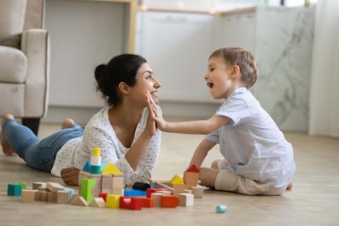 Girl playing building blocks with her nanny at the park
